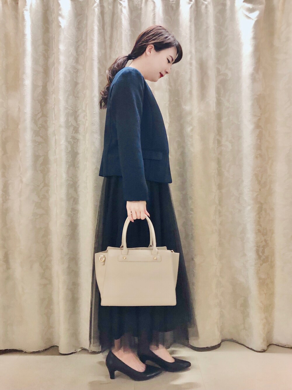 ブルー系のノーカラージャケット、ホワイト系のシャツ/ブラウス、ブラック系のパンプスを着用したレディースの春コーディネートの2枚目の写真