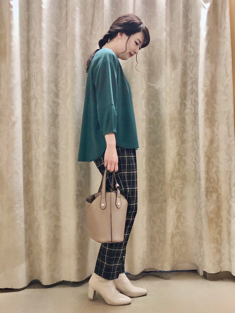 ベージュ系のトートバッグ、ホワイト系のブーツ、グリーン系のTシャツ/カットソーを着用したレディースの秋コーディネートの2枚目の写真