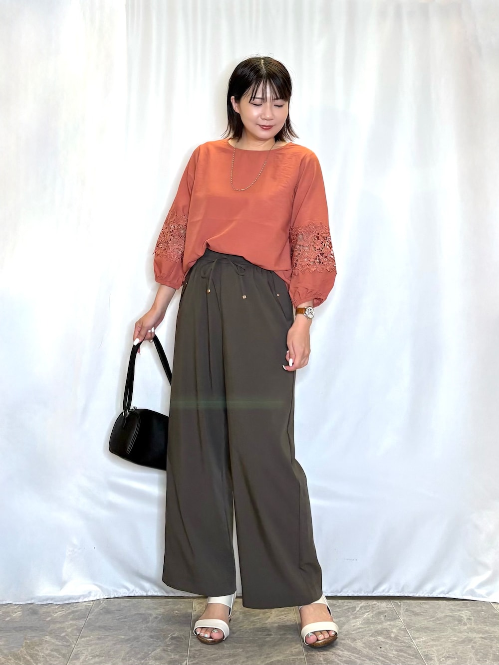 レッド系のシャツ/ブラウス、ブラウン系のその他パンツ、ホワイト系のサンダルを着用したレディースの夏コーディネートの2枚目の写真