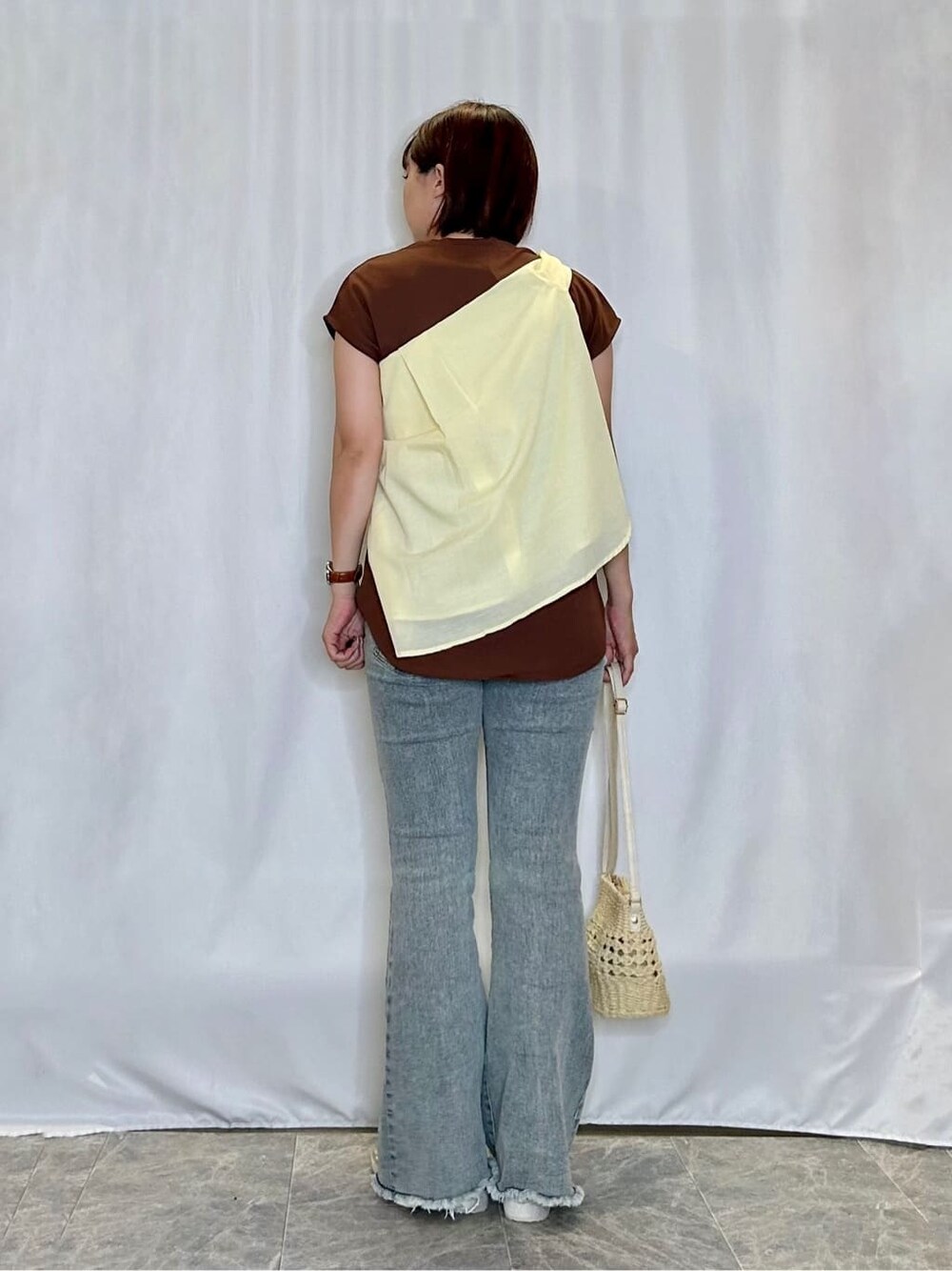 イエロー系のシャツ/ブラウス、ブラウン系のTシャツ/カットソー、ブルー系のデニムパンツを着用したレディースの夏コーディネートの3枚目の写真