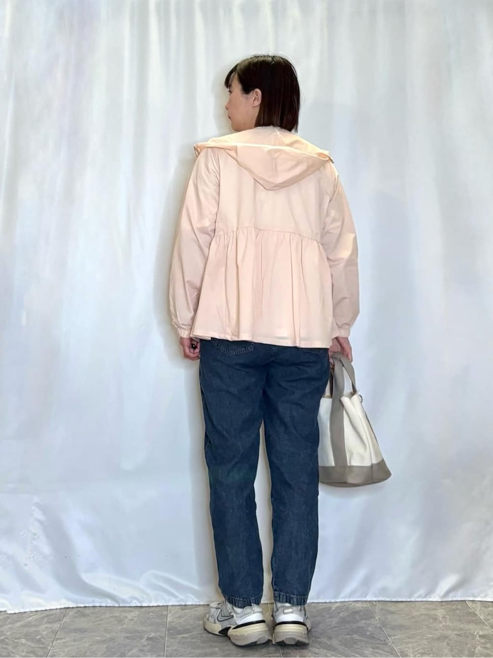 ピンク系のブルゾン、ホワイト系のTシャツ/カットソー、ブルー系のデニムパンツを着用したレディースの春コーディネートの3枚目の写真