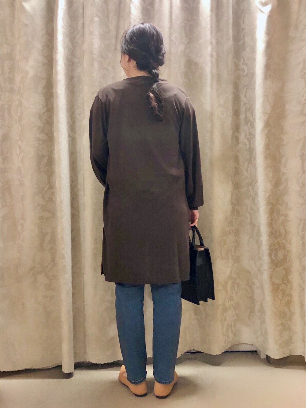 ブルー系のデニムパンツ、イエロー系のパンプス、ブラック系のショルダーバッグを着用したレディースの秋コーディネートの3枚目の写真
