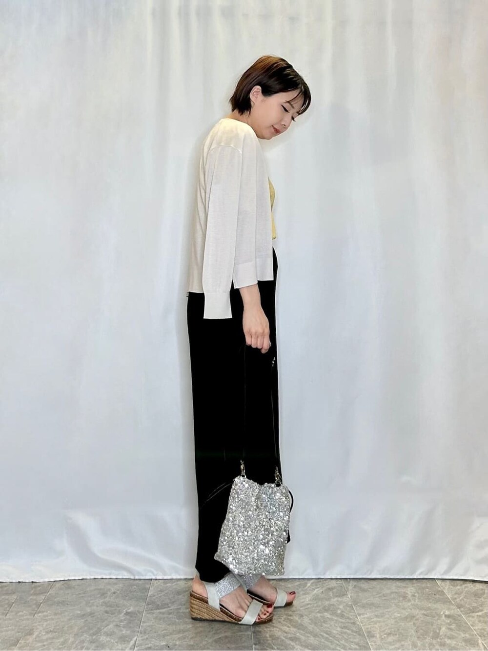 グレー系のカーディガン/ボレロ、イエロー系のTシャツ/カットソー、ブラック系のスカートを着用したレディースの夏コーディネートの2枚目の写真