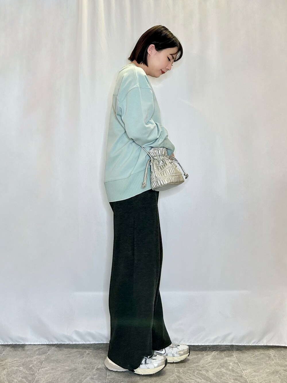 グリーン系のTシャツ/カットソー、ブラック系のその他パンツ、シルバー系のショルダーバッグを着用したレディースの冬コーディネートの2枚目の写真