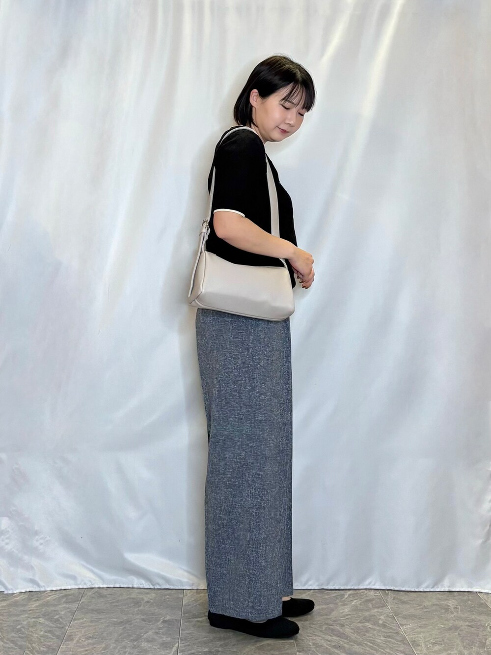 ブラック系のニット/セーター、ブルー系のその他パンツ、ブラック系のパンプスを着用したレディースの夏コーディネートの2枚目の写真