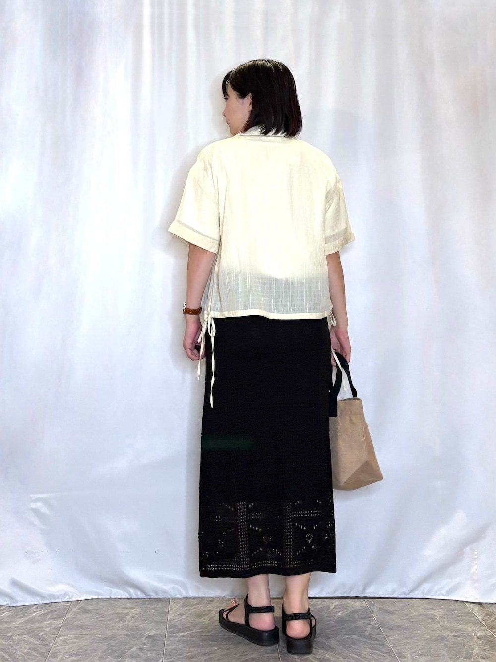 イエロー系のシャツ/ブラウス、ホワイト系のTシャツ/カットソー、ブラック系のスカートを着用したレディースの夏コーディネートの3枚目の写真