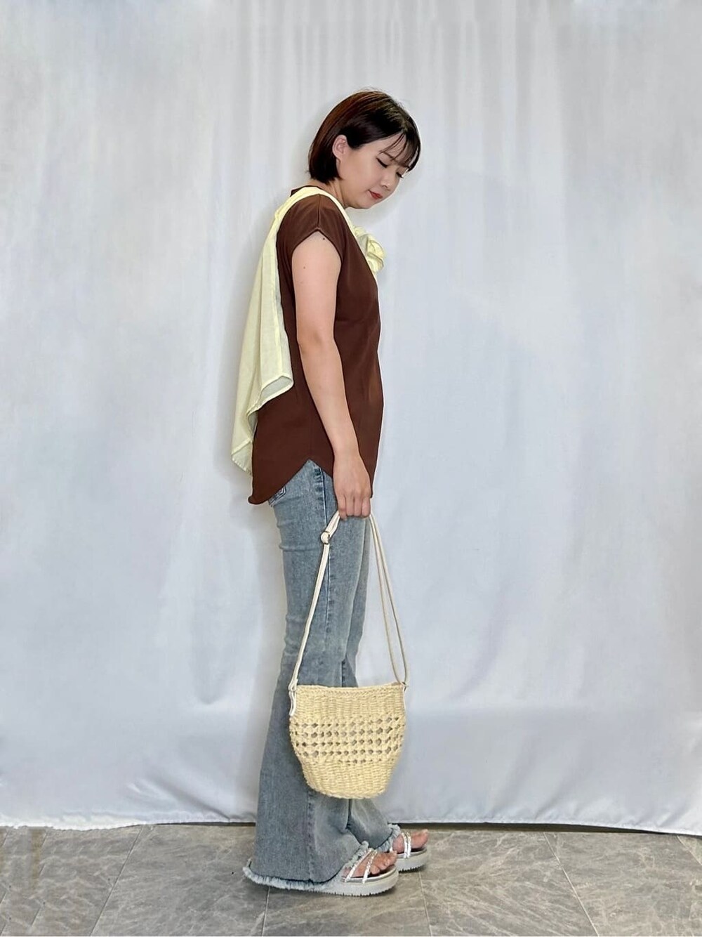 イエロー系のシャツ/ブラウス、ブラウン系のTシャツ/カットソー、ブルー系のデニムパンツを着用したレディースの夏コーディネートの2枚目の写真