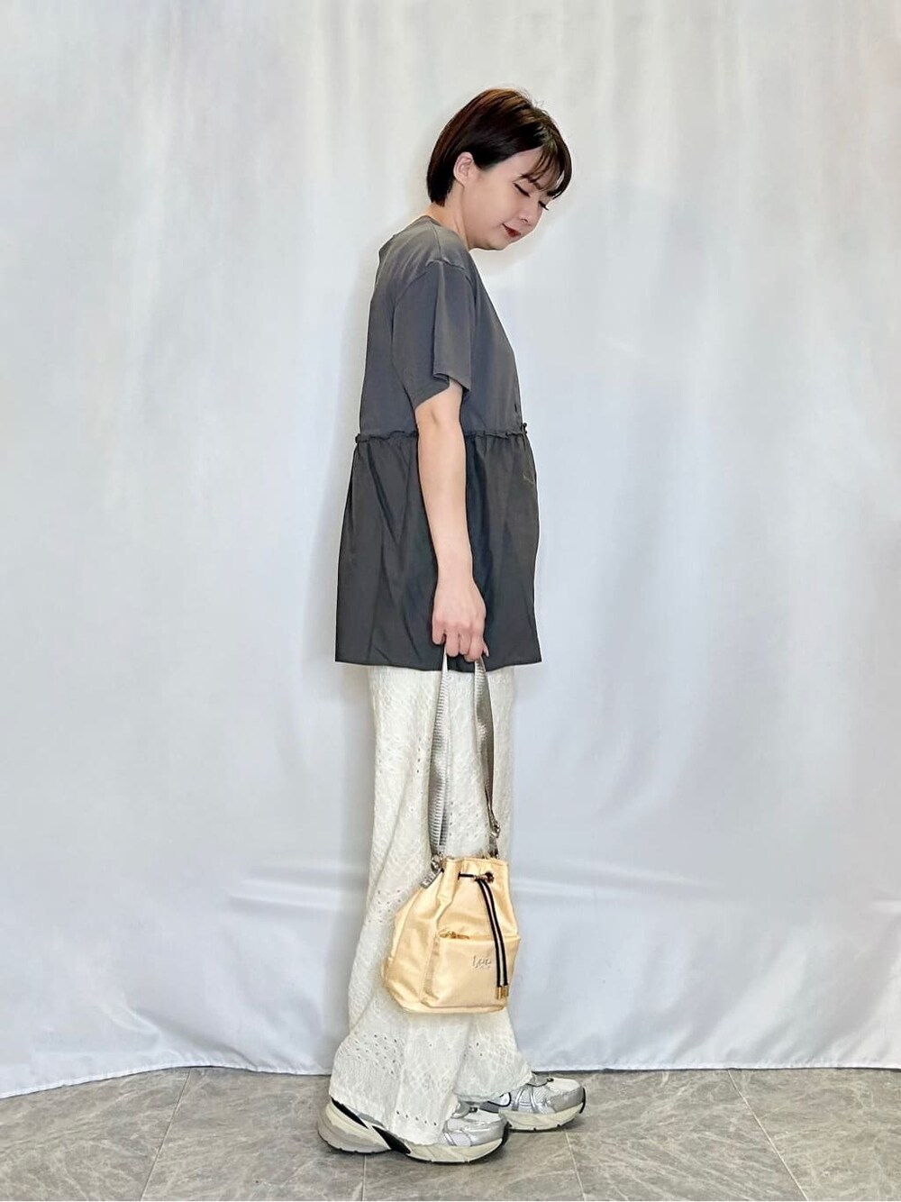 グレー系のTシャツ/カットソー、ホワイト系のその他パンツ、イエロー系のショルダーバッグを着用したレディースの春コーディネートの2枚目の写真