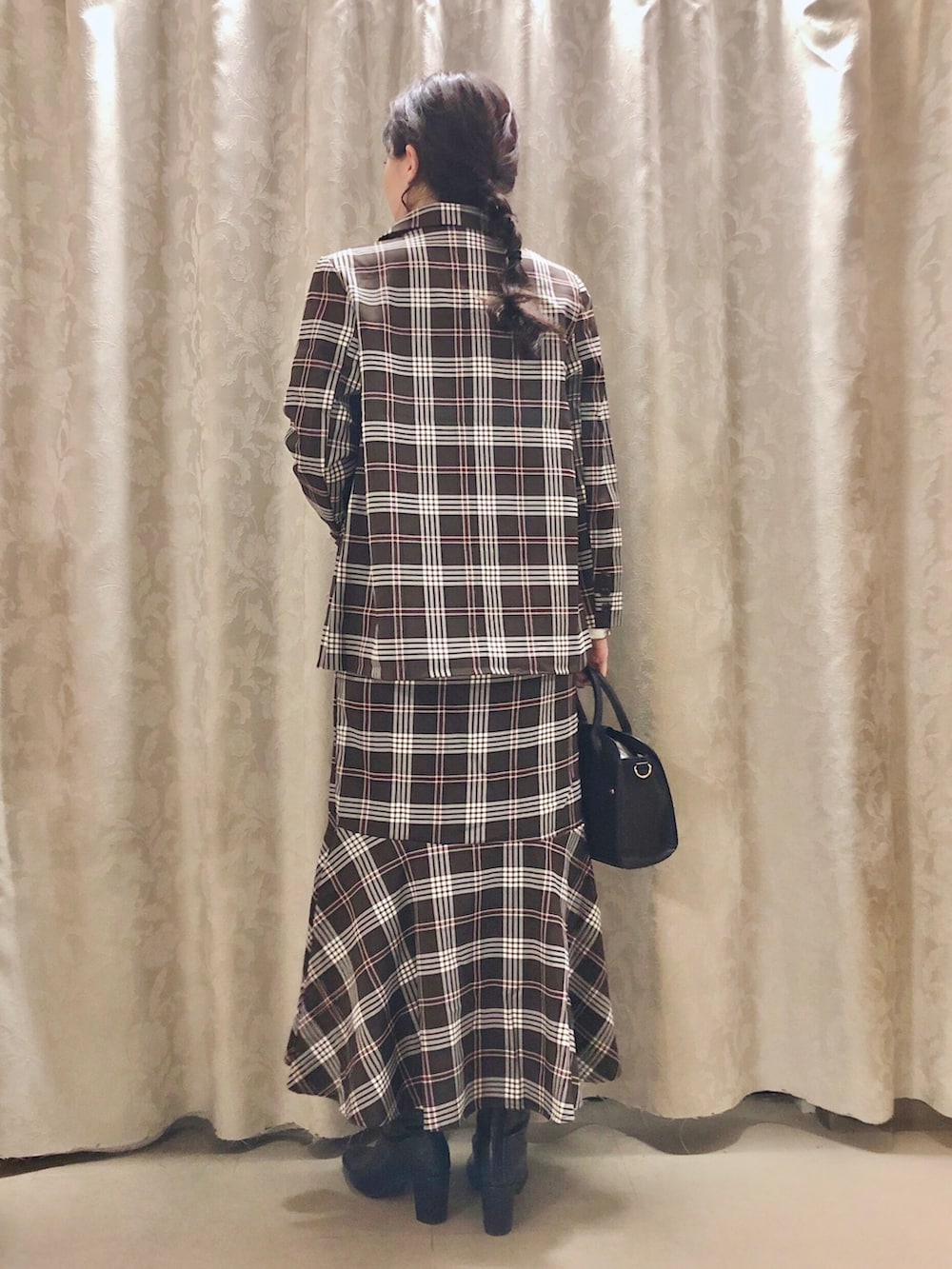 ブラック系のショルダーバッグ、ブラック系のブーツ、ブラウン系のテーラードジャケットを着用したレディースの秋コーディネートの3枚目の写真