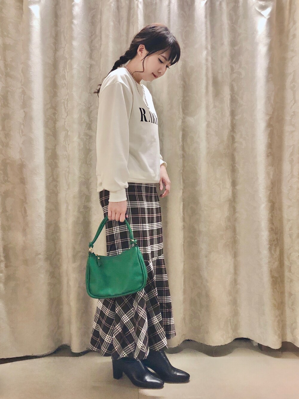 グリーン系のショルダーバッグ、ブラック系のブーツ、ベージュ系のスウェットを着用したレディースの秋コーディネートの2枚目の写真