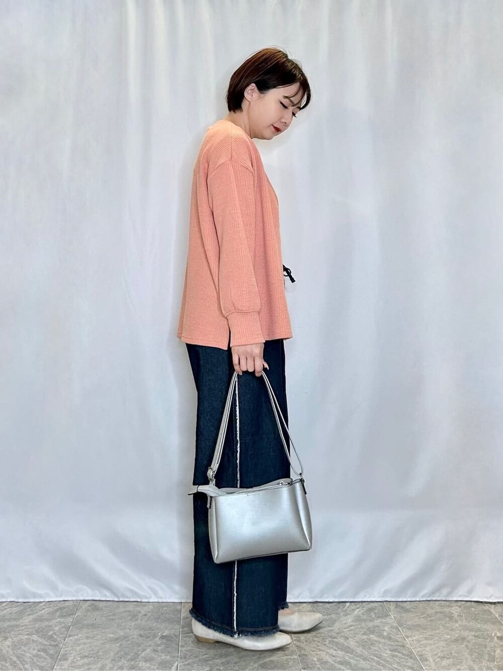 オレンジ系のカーディガン/ボレロ、ホワイト系のタンクトップ、ブルー系のデニムパンツを着用したレディースの春コーディネートの2枚目の写真