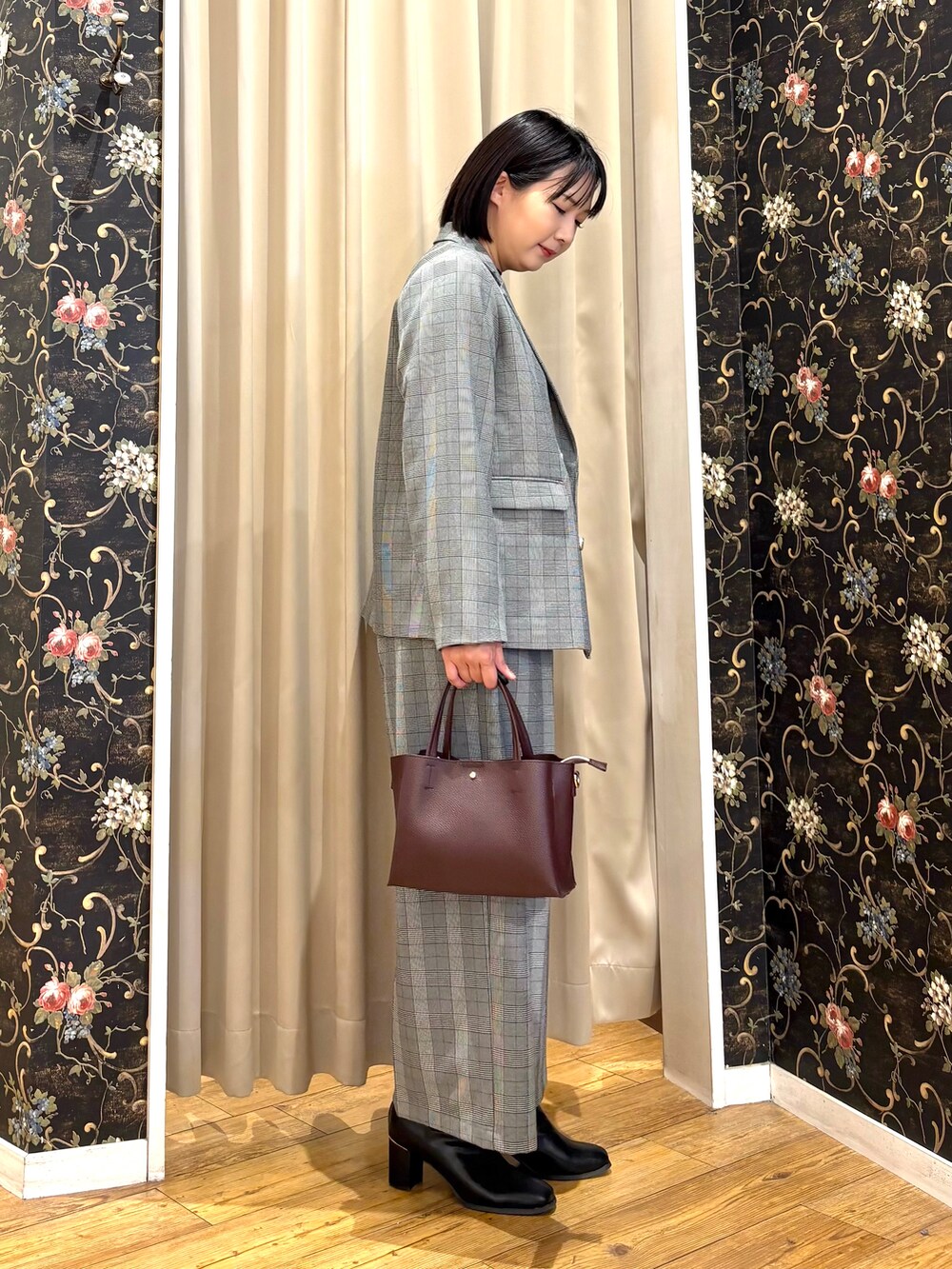 グレー系のテーラードジャケット、ブラック系のニット/セーター、グレー系のその他パンツを着用したレディースの秋コーディネートの2枚目の写真