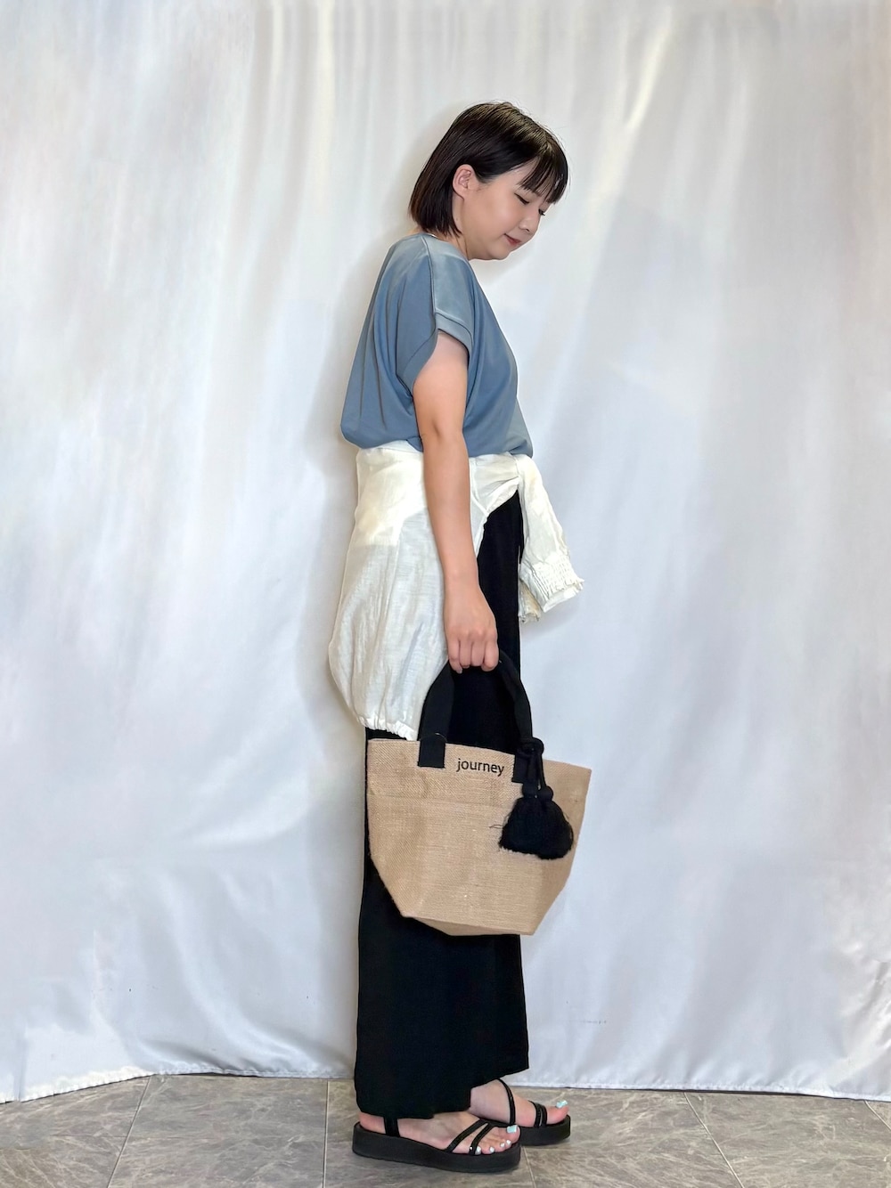 ホワイト系のブルゾン、ブルー系のTシャツ/カットソー、ブラック系のサンダルを着用したレディースの夏コーディネートの2枚目の写真