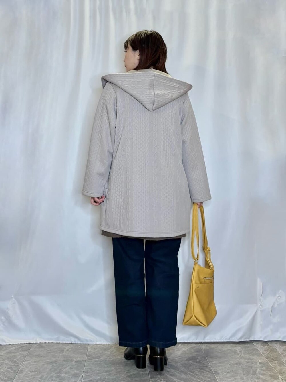 ベージュ系のカーディガン/ボレロ、ブラウン系のチュニック、ブルー系のデニムパンツを着用したレディースの秋コーディネートの3枚目の写真