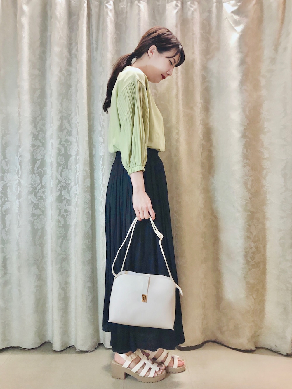 グリーン系のシャツ/ブラウス、ブルー系のスカート、ホワイト系のショルダーバッグを着用したレディースの春コーディネートの2枚目の写真