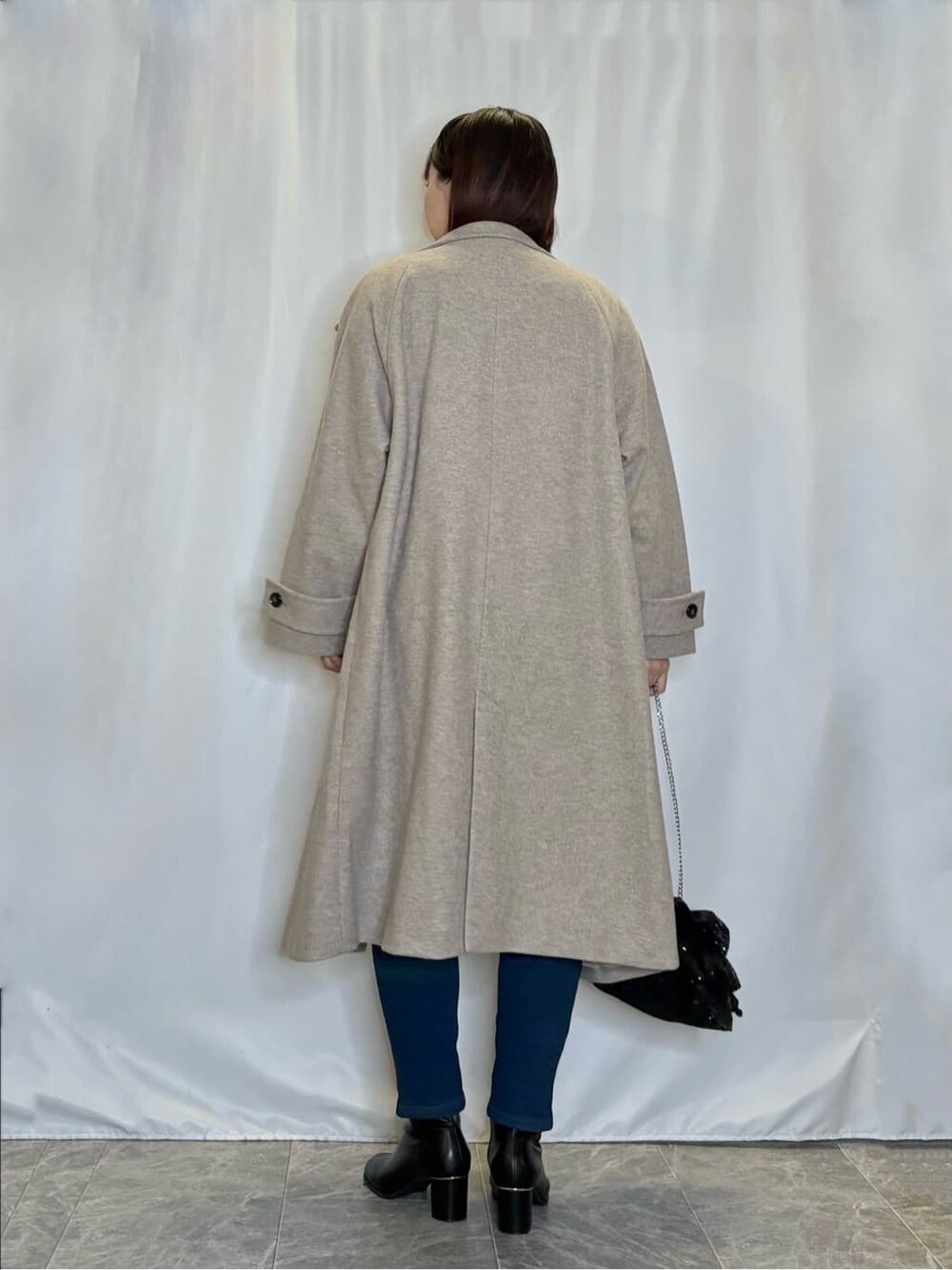 ベージュ系のその他アウター、イエロー系のニット/セーター、ブルー系のその他パンツを着用したレディースの冬コーディネートの3枚目の写真