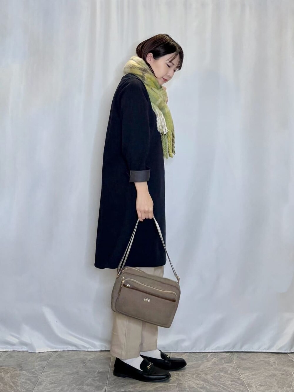 ブルー系のチュニック、ベージュ系のその他パンツ、ブラック系のその他シューズを着用したレディースの冬コーディネートの2枚目の写真