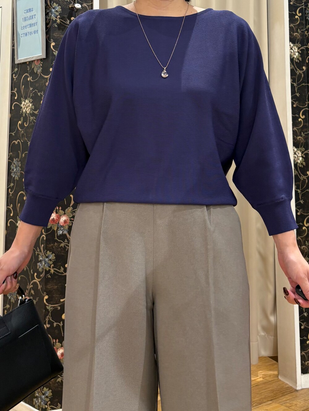 ブルー系のニット/セーター、ベージュ系のその他パンツ、ブラック系のショルダーバッグを着用したレディースの秋コーディネートの4枚目の写真