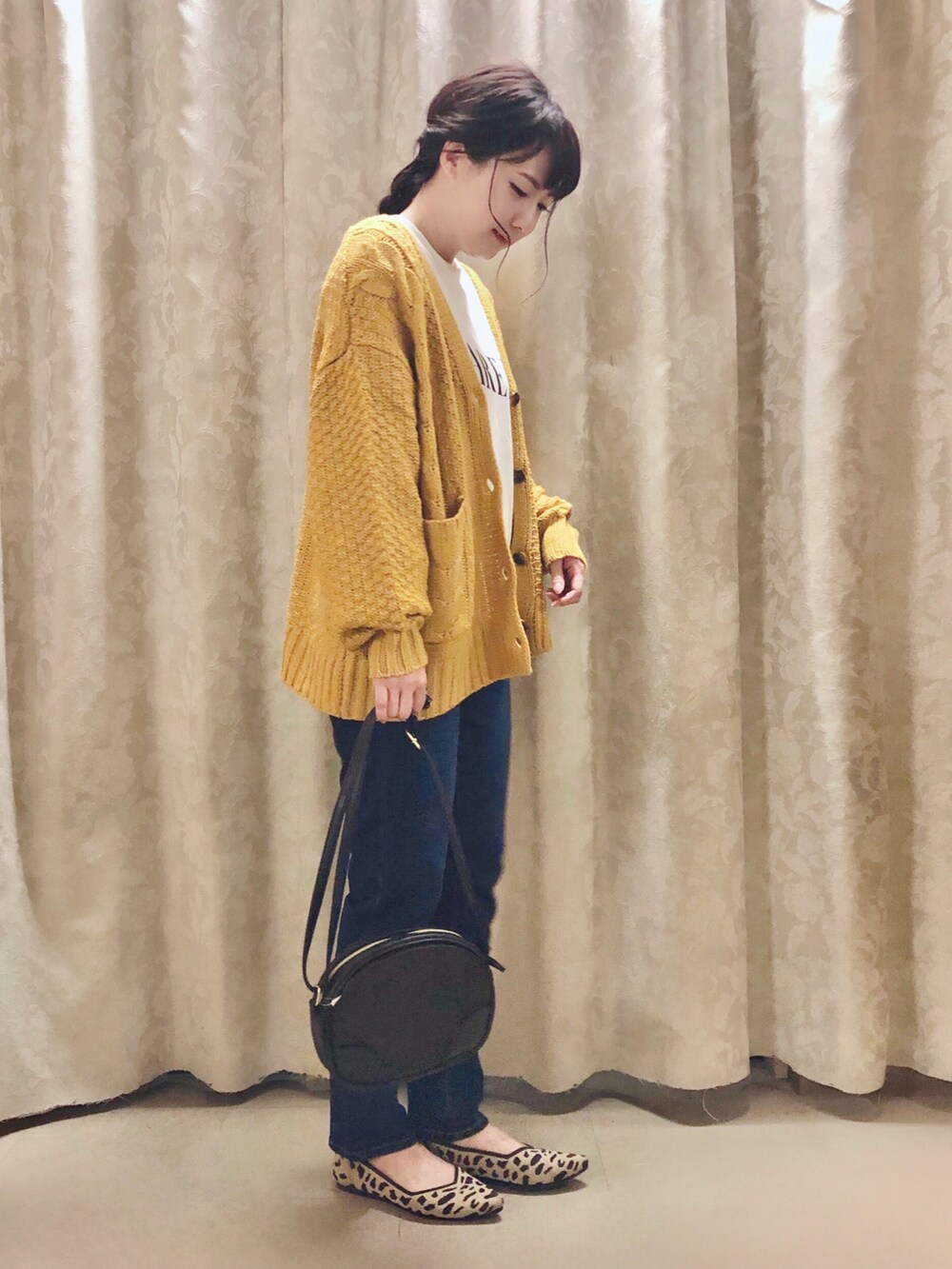 イエロー系のカーディガン/ボレロ、ベージュ系のスウェット、ブラウン系のパンプスを着用したレディースの秋コーディネートの2枚目の写真