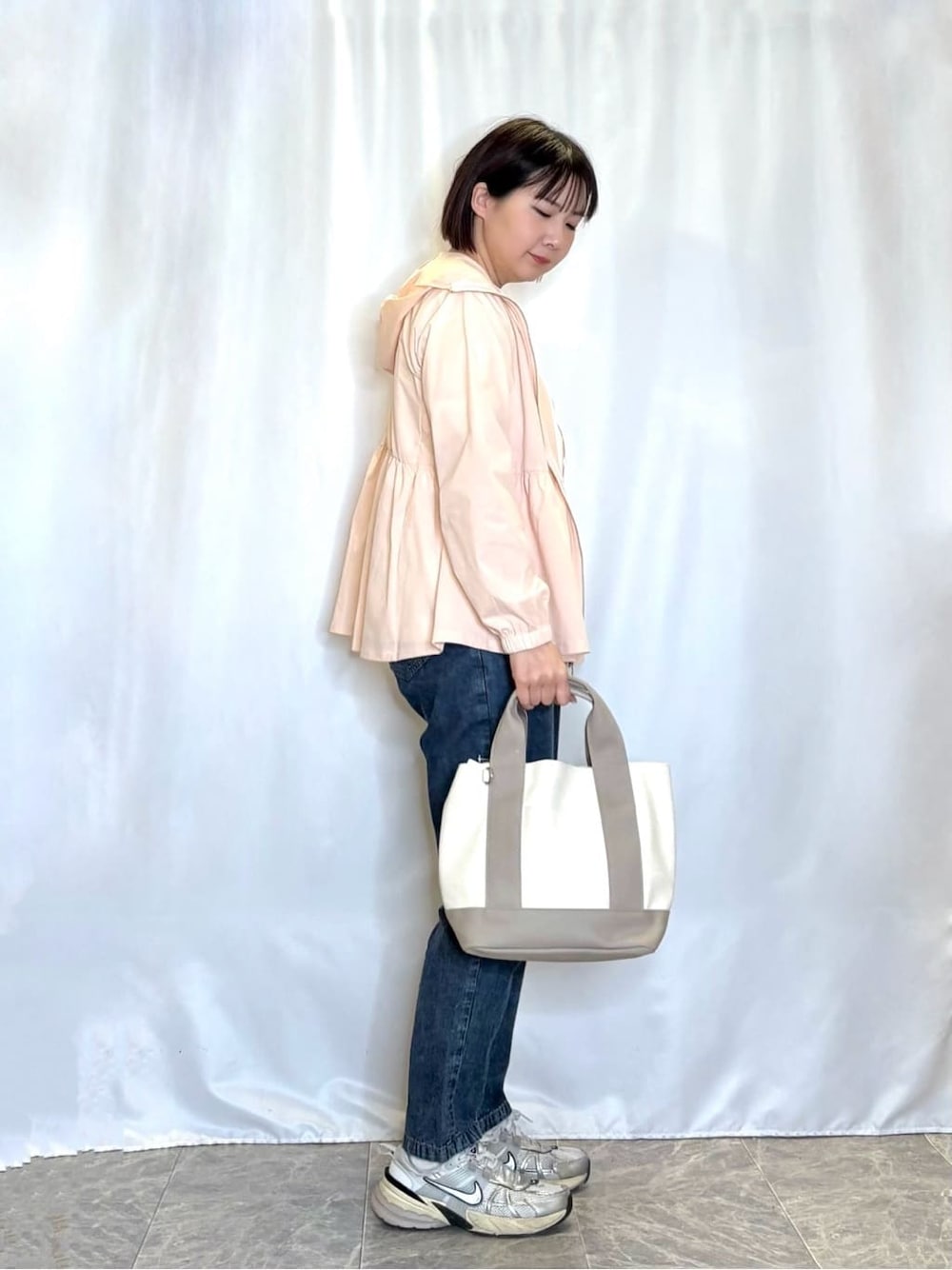 ピンク系のブルゾン、ホワイト系のTシャツ/カットソー、ブルー系のデニムパンツを着用したレディースの春コーディネートの2枚目の写真
