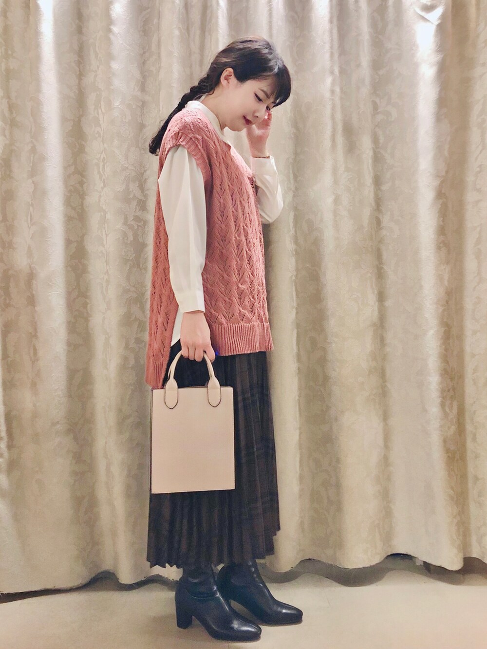 ホワイト系のシャツ/ブラウス、ピンク系のベスト、ブラック系のブーツを着用したレディースの秋コーディネートの2枚目の写真