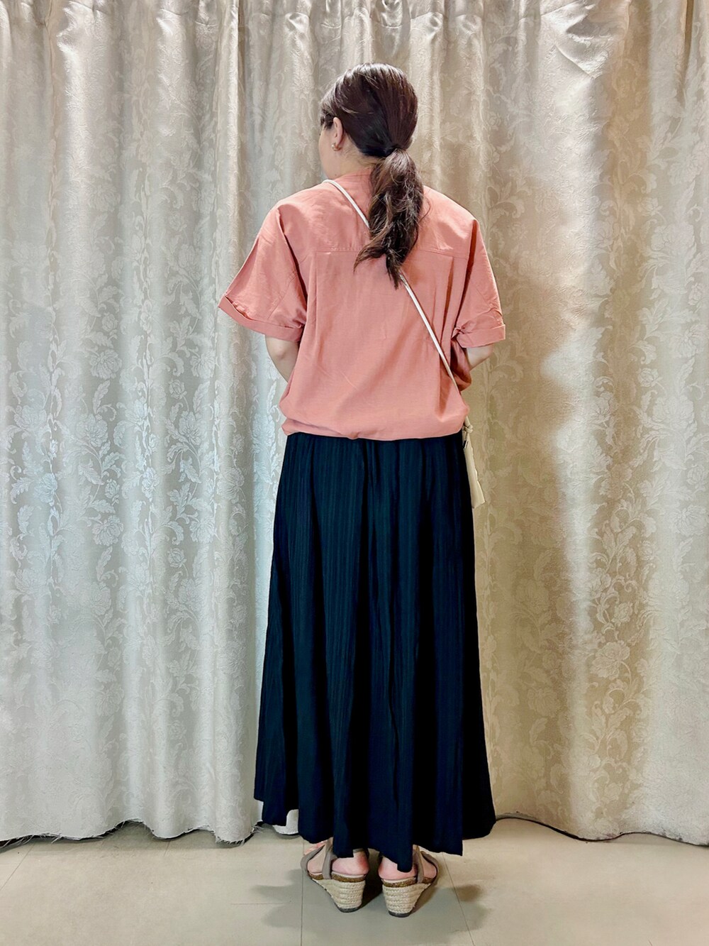 ピンク系のシャツ/ブラウス、ブラック系のスカート、ホワイト系のショルダーバッグを着用したレディースの夏コーディネートの3枚目の写真