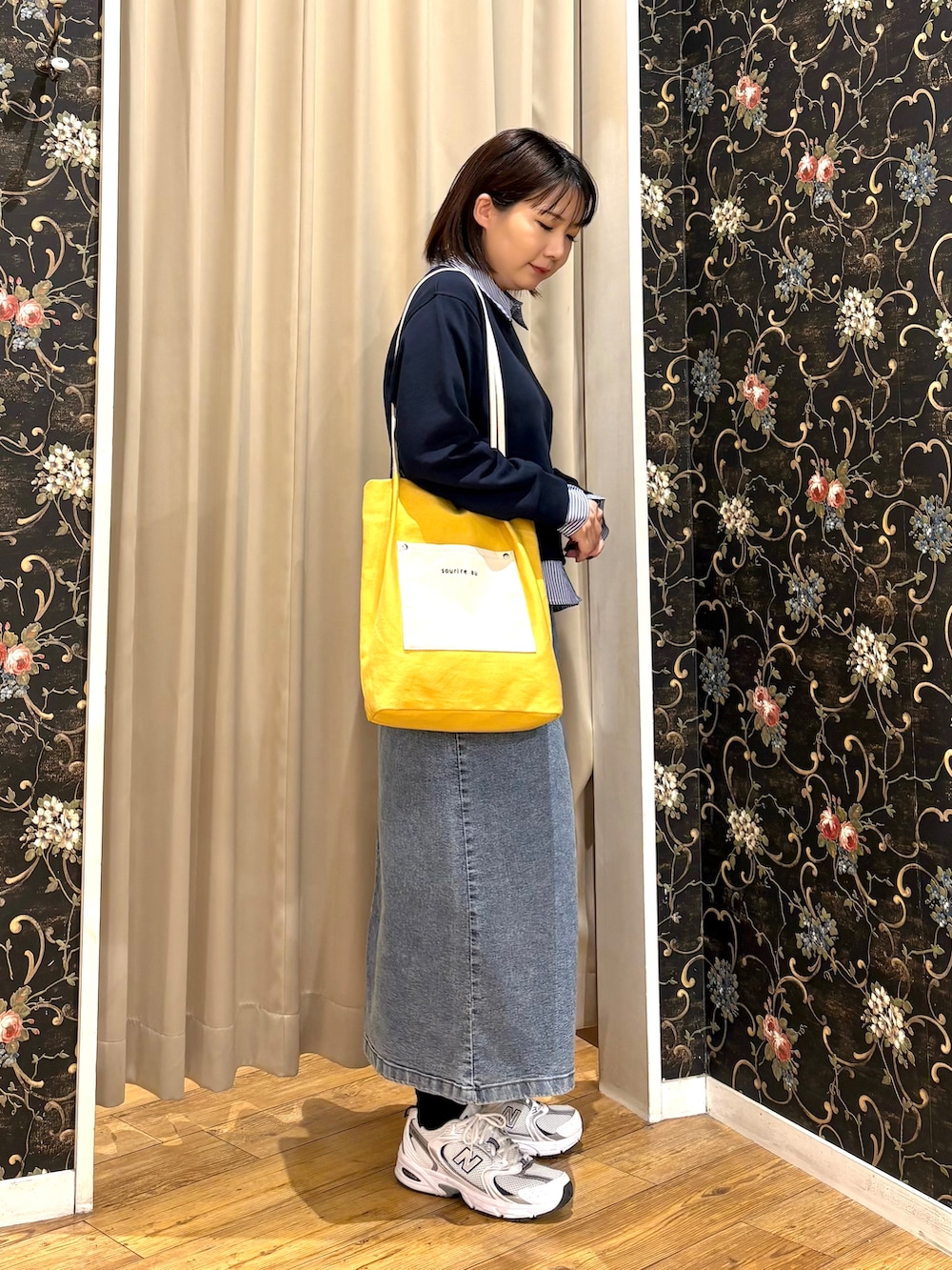 ブルー系のTシャツ/カットソー、ブルー系のデニムスカート、イエロー系のトートバッグを着用したレディースの秋コーディネートの2枚目の写真