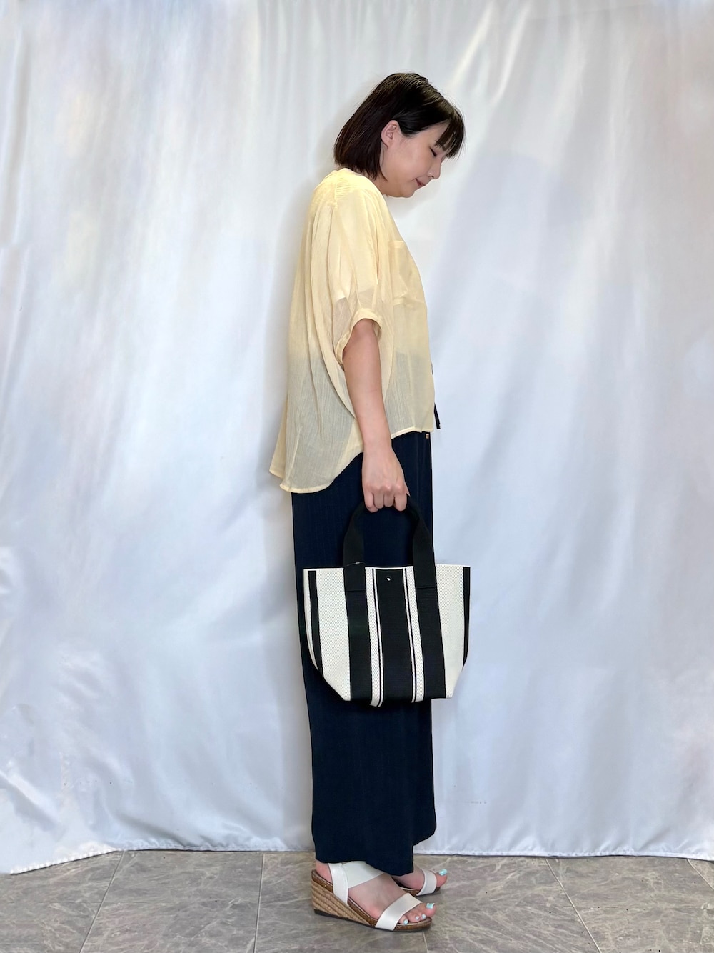 イエロー系のシャツ/ブラウス、ホワイト系のTシャツ/カットソー、ホワイト系のサンダルを着用したレディースの夏コーディネートの3枚目の写真
