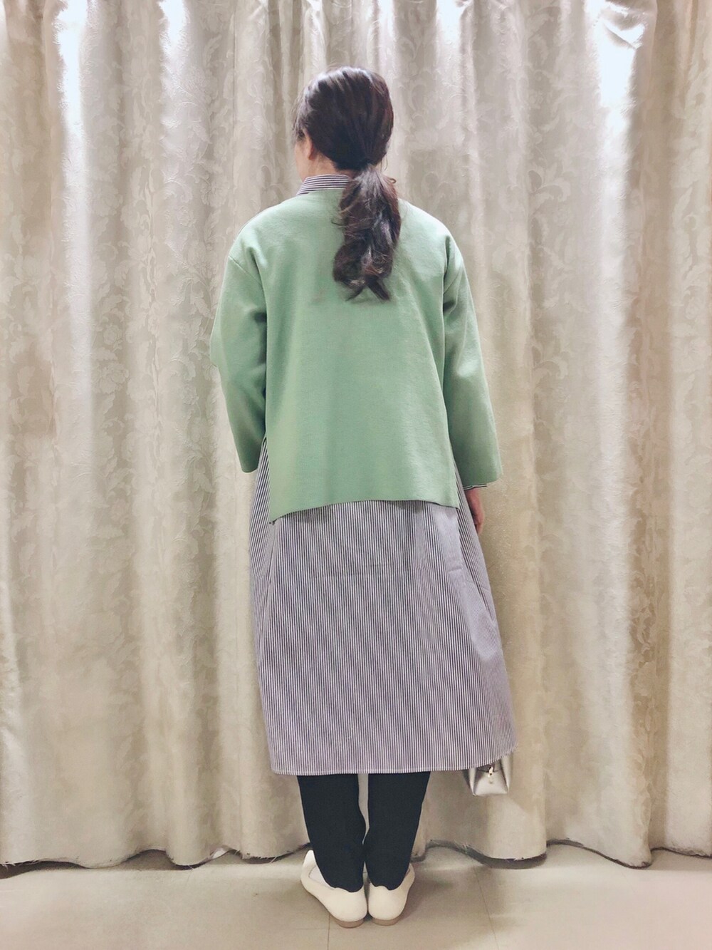 ブルー系のワンピース、グリーン系のニット/セーター、ブラック系のその他パンツを着用したレディースの冬コーディネートの3枚目の写真