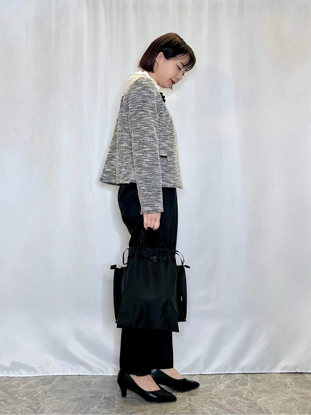 ブラック系のノーカラージャケット、ホワイト系のシャツ/ブラウス、ブラック系のその他パンツを着用したレディースの冬コーディネートの2枚目の写真