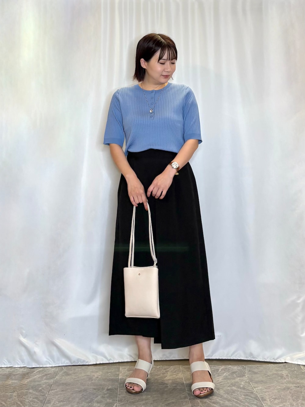 ブルー系のニット/セーター、ブラック系のその他パンツ、ホワイト系のサンダルを着用したレディースの夏コーディネートの2枚目の写真