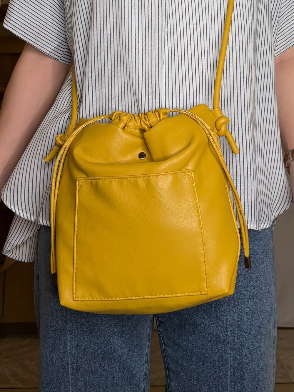 ホワイト系のその他トップス、ブルー系のデニムパンツ、イエロー系のショルダーバッグを着用したレディースの秋コーディネートの5枚目の写真