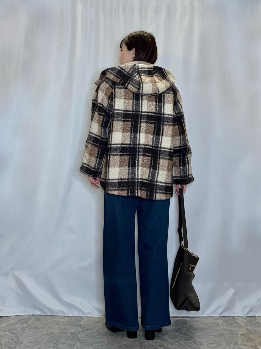 ブラウン系のその他アウター、ベージュ系のニット/セーター、ブルー系のデニムパンツを着用したレディースの冬コーディネートの3枚目の写真