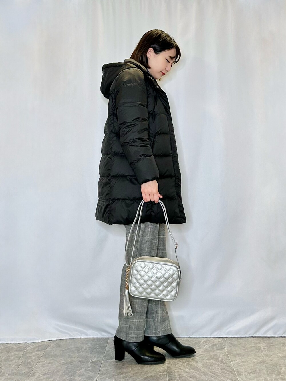 シルバー系のショルダーバッグ、グレー系のその他パンツ、ブラック系のダウンジャケット/コートを着用したレディースの冬コーディネートの2枚目の写真