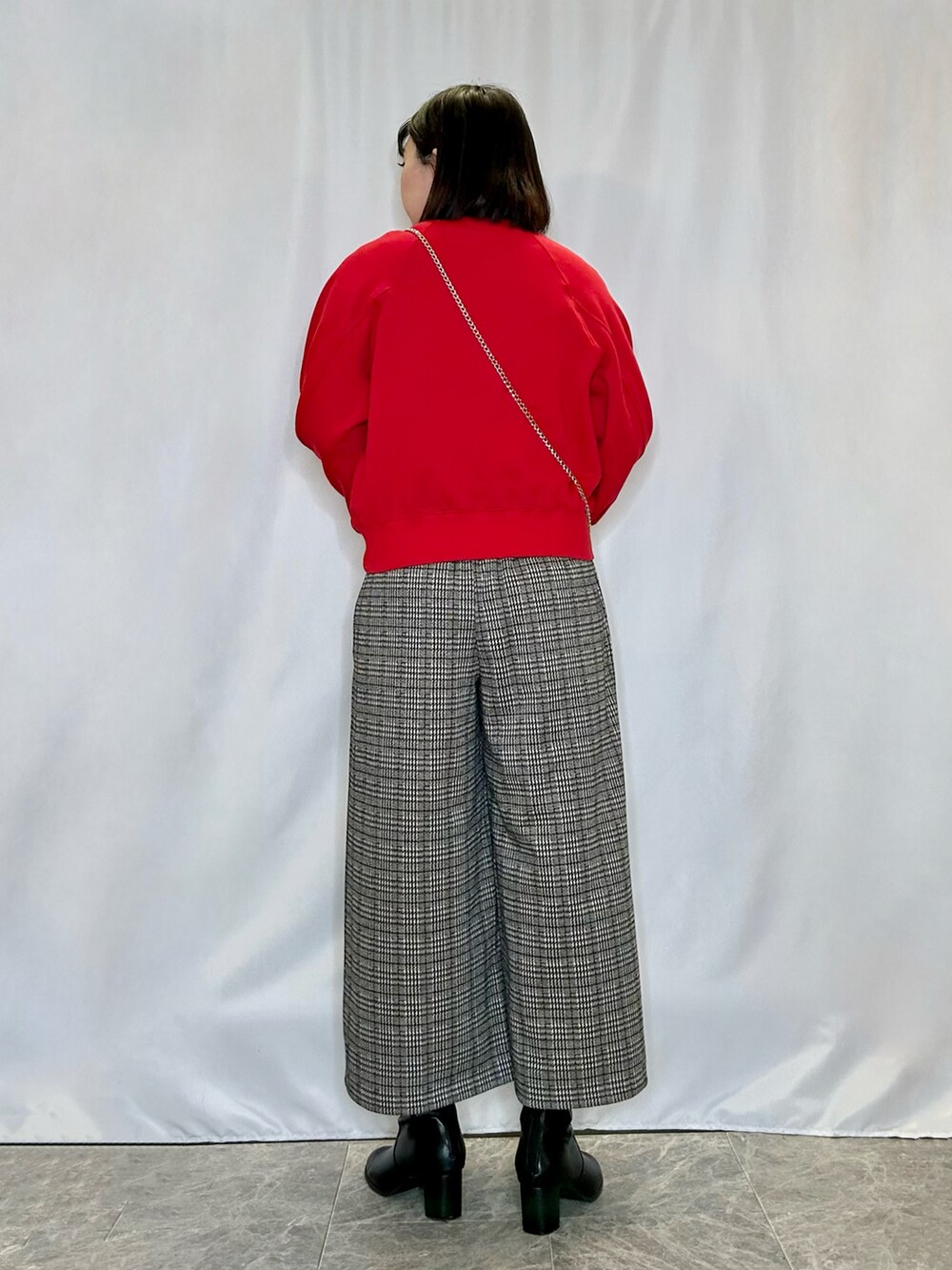 ブラック系のブーツ、レッド系のTシャツ/カットソー、ベージュ系のその他パンツを着用したレディースの冬コーディネートの3枚目の写真