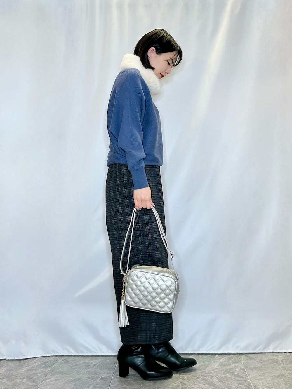 ブラック系のブーツ、グレー系のその他パンツ、シルバー系のショルダーバッグを着用したレディースの冬コーディネートの2枚目の写真