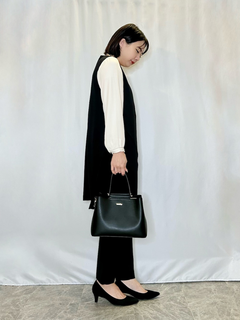 ブラック系のパンプス、ブラック系のその他パンツ、ブラック系のトートバッグを着用したレディースの冬コーディネートの2枚目の写真