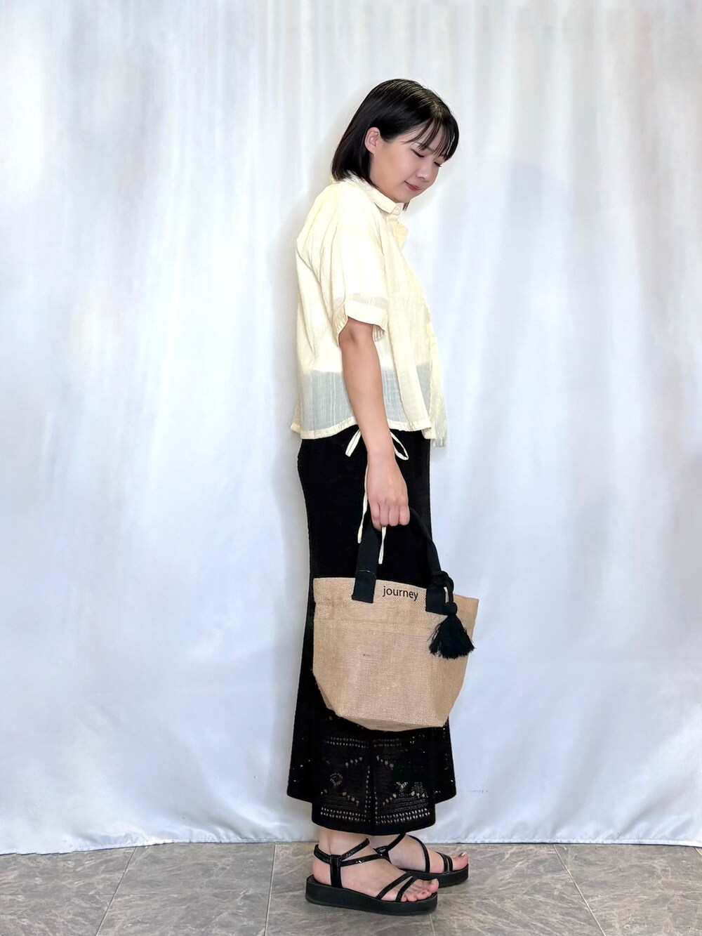 イエロー系のシャツ/ブラウス、ホワイト系のTシャツ/カットソー、ブラック系のスカートを着用したレディースの夏コーディネートの2枚目の写真