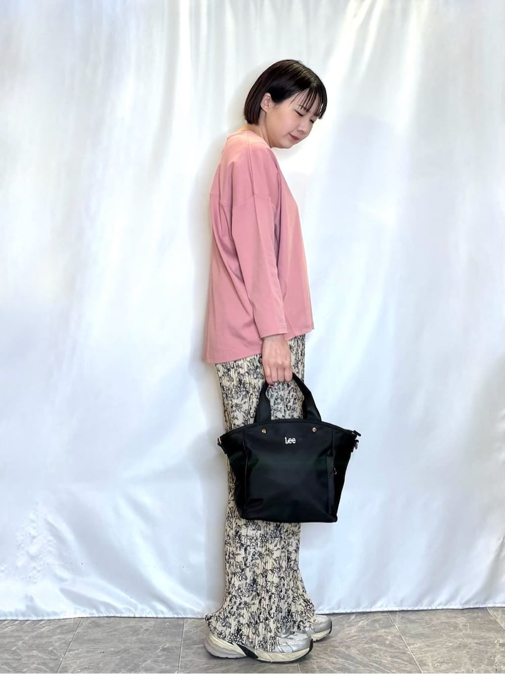 ピンク系のTシャツ/カットソー、ベージュ系のその他パンツ、ブラック系のトートバッグを着用したレディースの春コーディネートの2枚目の写真