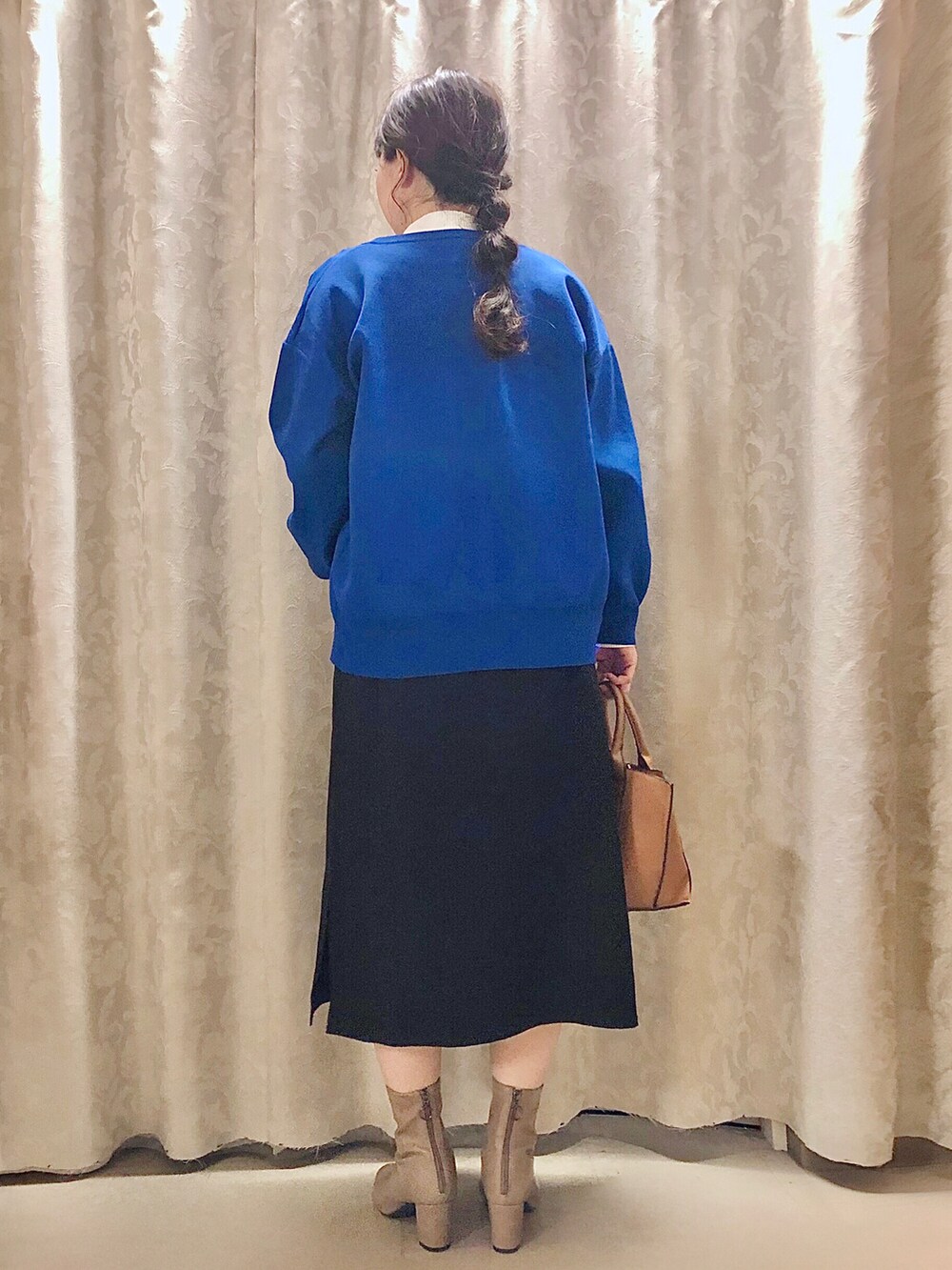 イエロー系のトートバッグ、ベージュ系のブーツ、ホワイト系のTシャツ/カットソーを着用したレディースの秋コーディネートの3枚目の写真