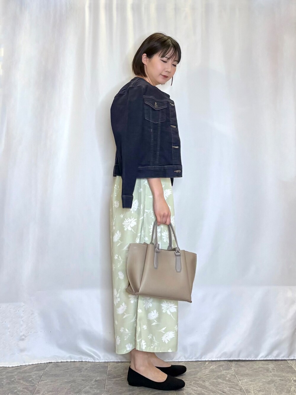 ブルー系のデニムジャケット、ベージュ系のニット/セーター、グリーン系のその他パンツを着用したレディースの春コーディネートの2枚目の写真