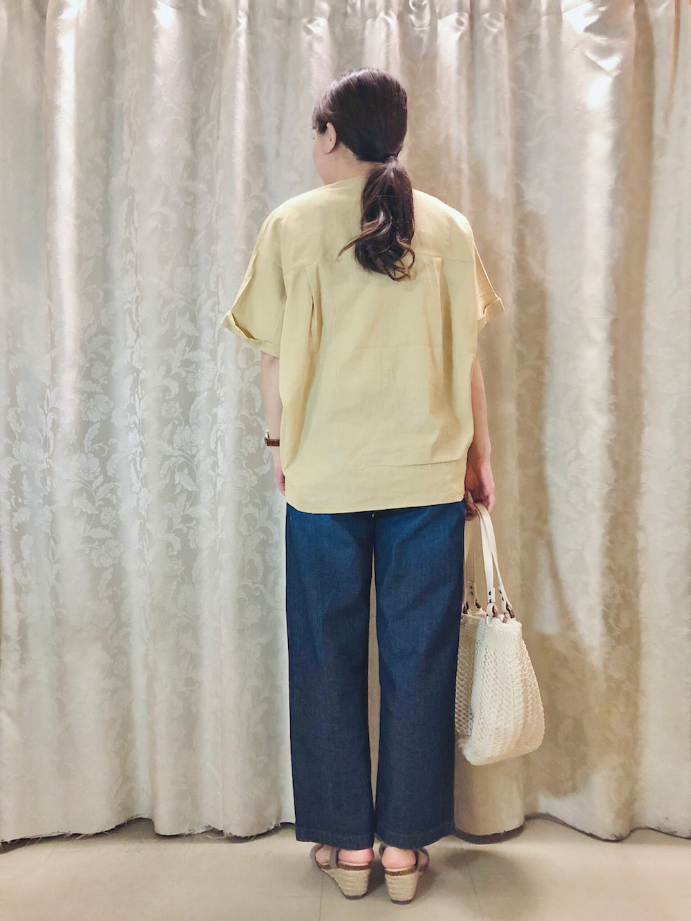 ブルー系のデニムパンツ、イエロー系のシャツ/ブラウス、ブラウン系のサンダルを着用したレディースの春コーディネートの3枚目の写真