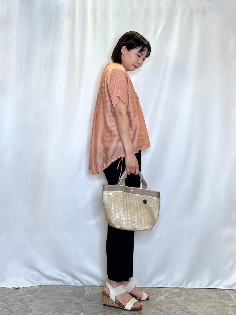 オレンジ系のシャツ/ブラウス、ベージュ系のニット/セーター、ブラック系のその他パンツを着用したレディースの夏コーディネートの2枚目の写真