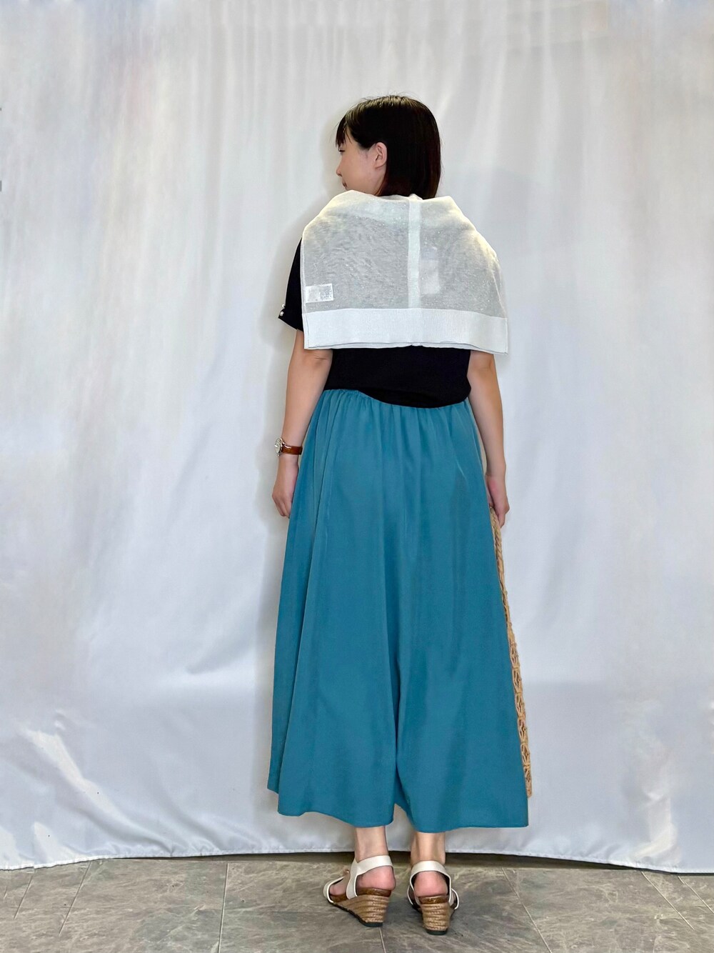 ホワイト系のカーディガン/ボレロ、ブラック系のTシャツ/カットソー、ブルー系のスカートを着用したレディースの夏コーディネートの3枚目の写真