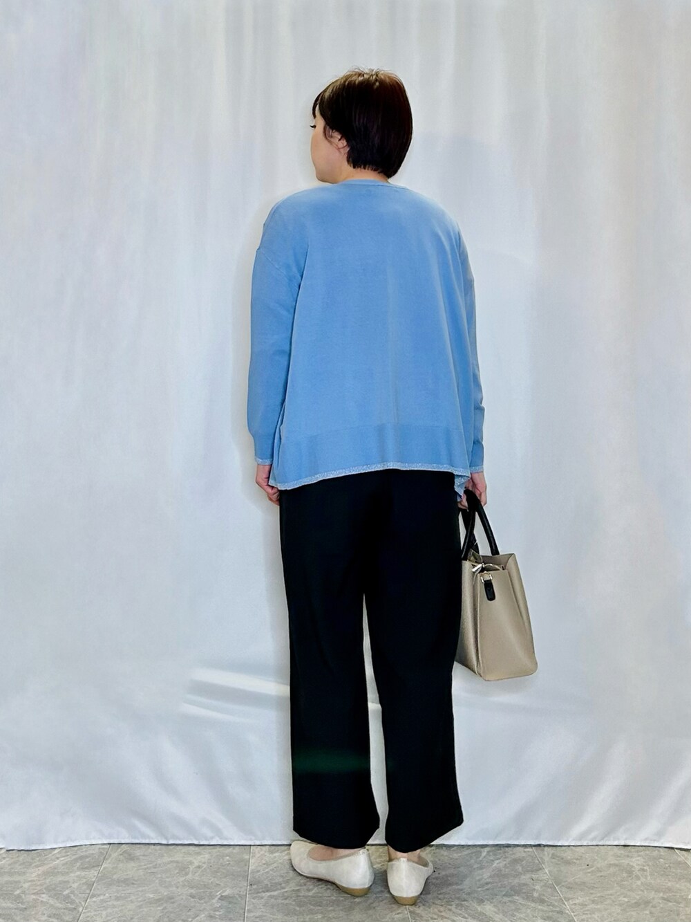 ホワイト系のTシャツ/カットソー、ブルー系のカーディガン/ボレロ、ベージュ系のトートバッグを着用したレディースの春コーディネートの3枚目の写真