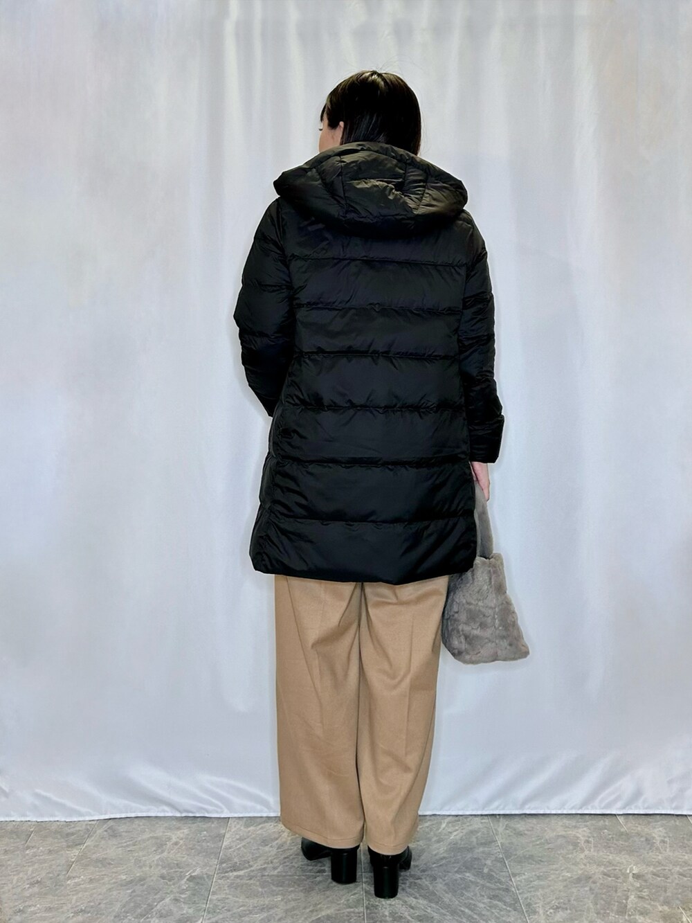 ブラック系のブーツ、ベージュ系のトートバッグ、イエロー系のその他パンツを着用したレディースの冬コーディネートの3枚目の写真