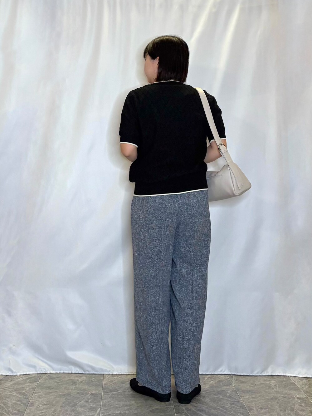 ブラック系のニット/セーター、ブルー系のその他パンツ、ブラック系のパンプスを着用したレディースの夏コーディネートの3枚目の写真