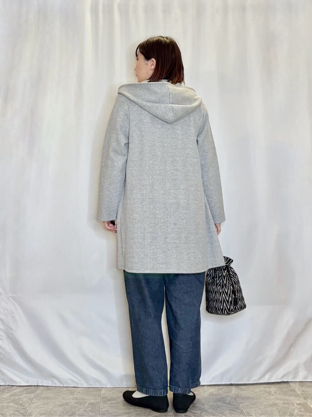 グレー系のその他アウター、グリーン系のTシャツ/カットソー、ブルー系のデニムパンツを着用したレディースの春コーディネートの3枚目の写真