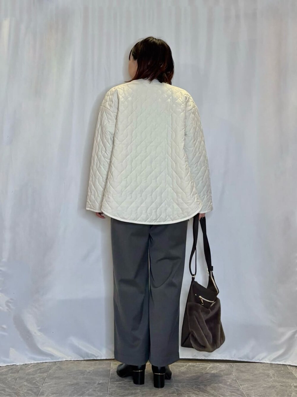 ホワイト系のノーカラージャケット、グリーン系のニット/セーター、グレー系のその他パンツを着用したレディースの冬コーディネートの3枚目の写真