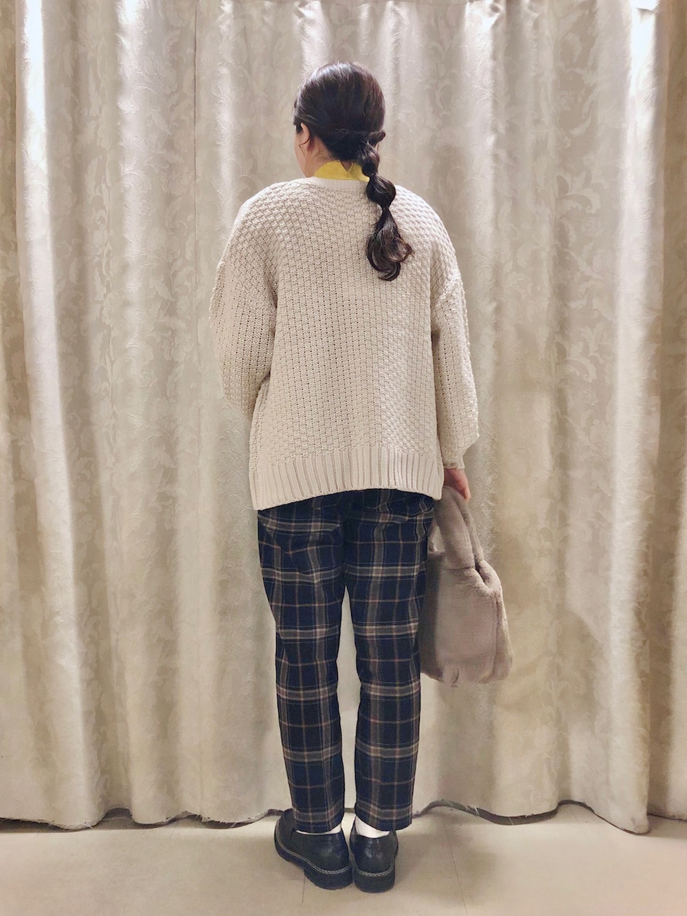 ブルー系のその他パンツ、イエロー系のニット/セーター、ブラック系のドレスシューズを着用したレディースの冬コーディネートの3枚目の写真
